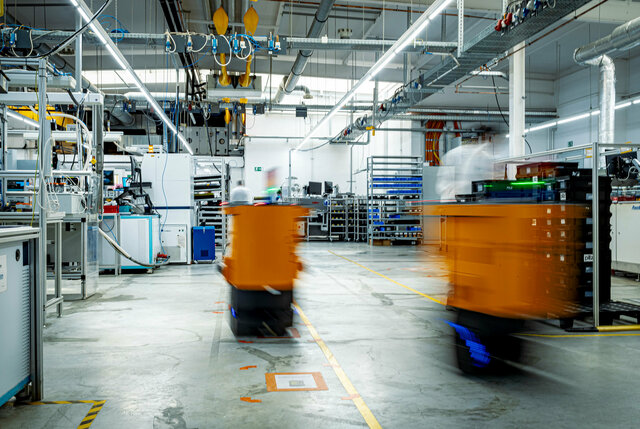 Two AGVs transport RevPi devices to the THT wave soldering system in production